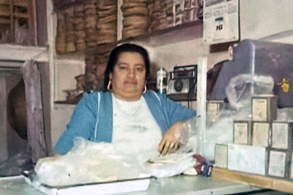 Fotografía antigua de la señora Manuela detrás del mostrador del local familiar
